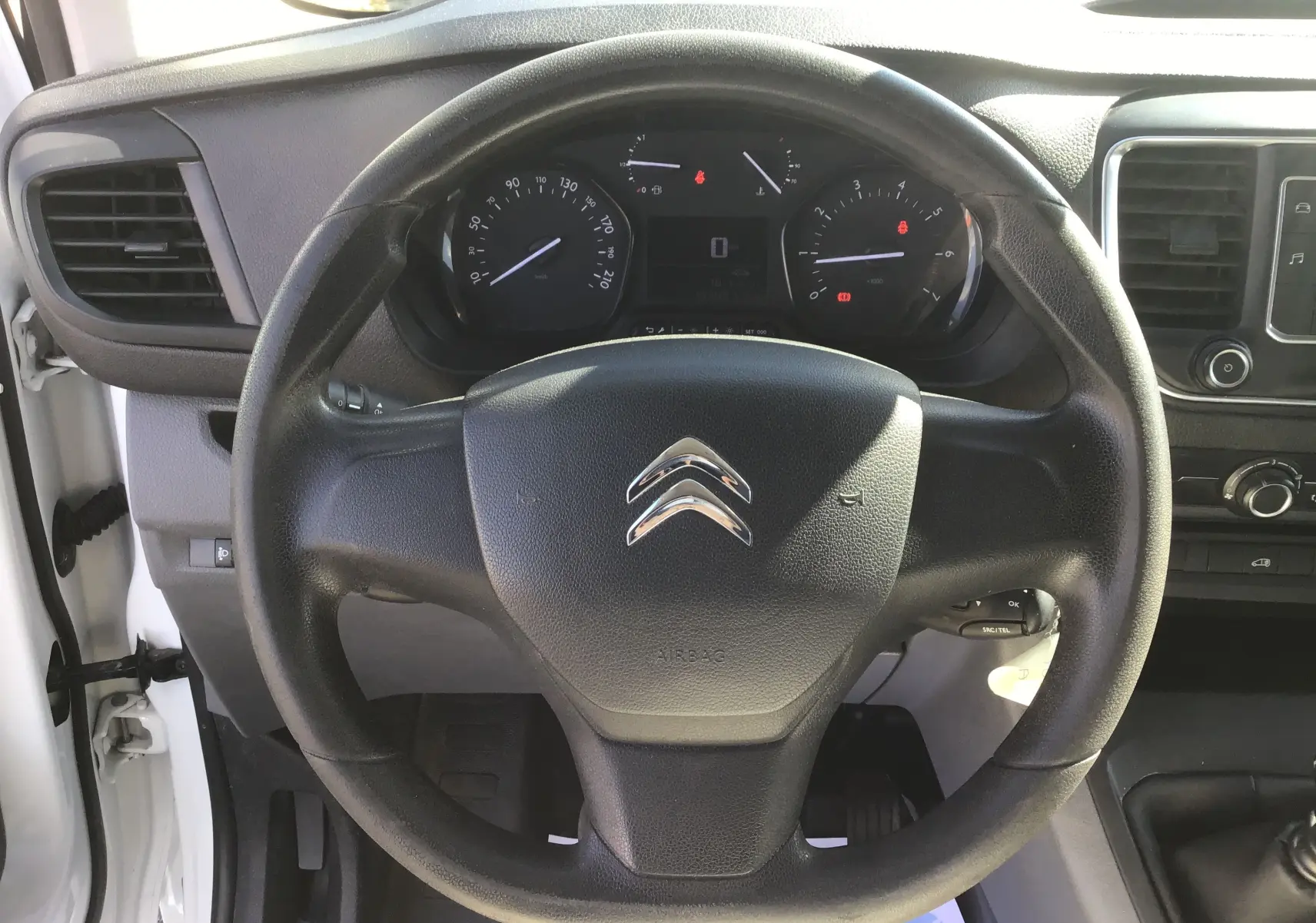 Vue frontale du volant noir du Citroën Jumpy XL 2.0 BlueHDi 120 Premium 2021 avec tableau de bord et commandes visibles.