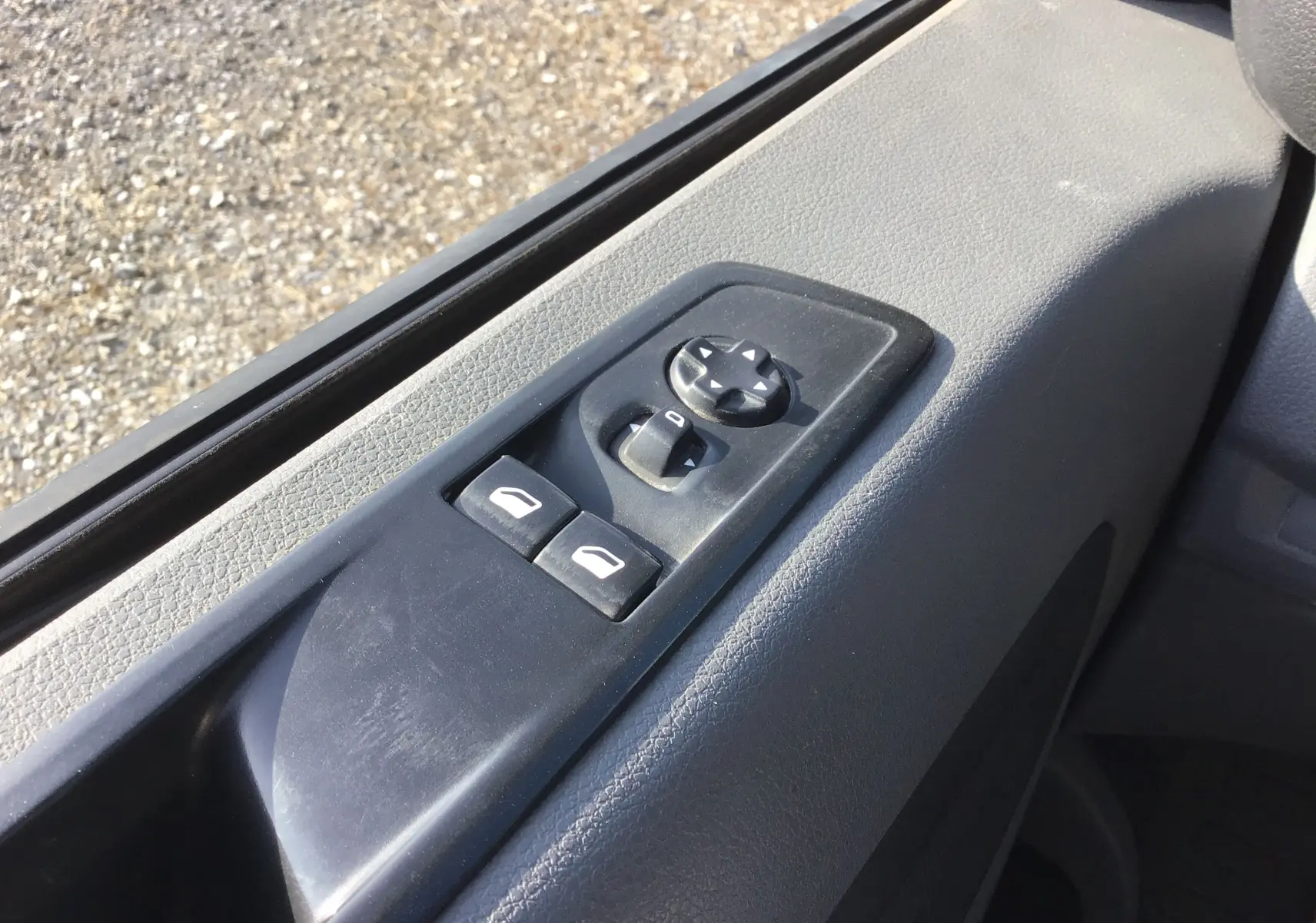 Gros plan sur les commandes électriques des vitres et rétroviseurs côté conducteur du Citroën Jumpy XL blanc 2021.