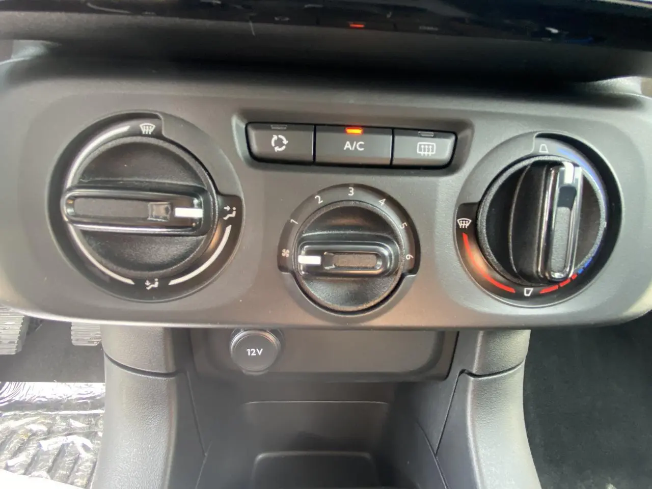 Panneau de commande de climatisation manuelle avec boutons A/C et prise 12V dans une Citroën C3 blanche de 2022.
