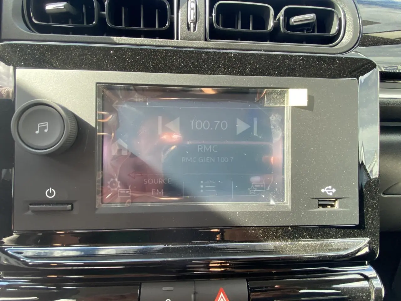 Écran tactile central du tableau de bord de la Citroën C3 blanche 2022, avec commandes audio et prise USB visible.