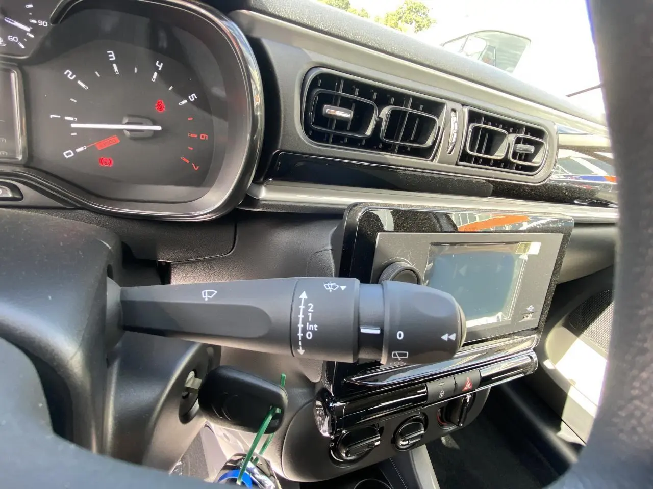Vue rapprochée du tableau de bord noir de la Citroën C3 2022, montrant commandes d'essuie-glace et écran tactile.