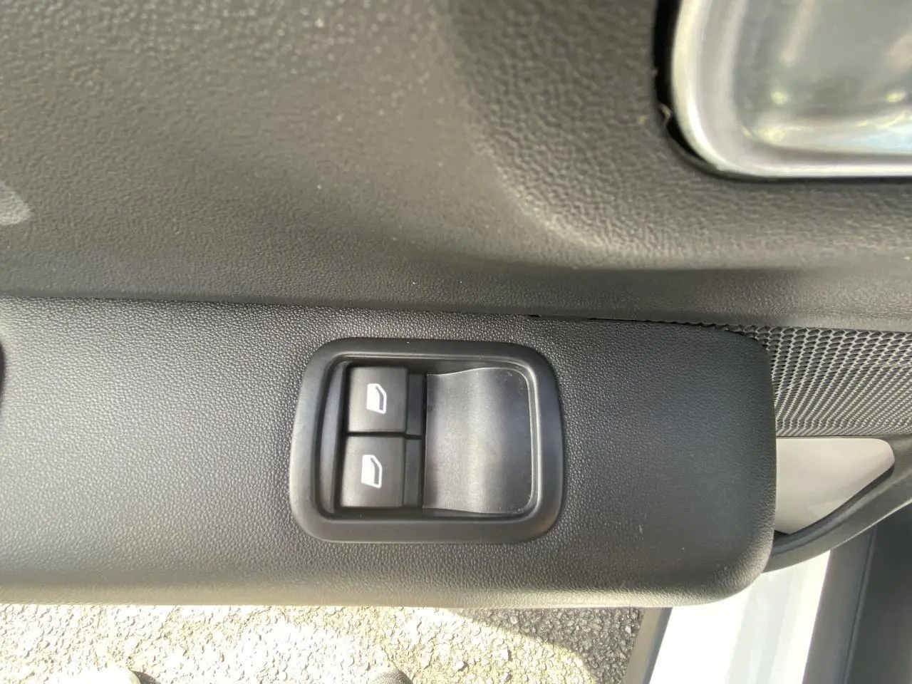 Boutons de commande des lève-vitres arrière sur la portière côté gauche d'une Citroën C3 blanche 2022.