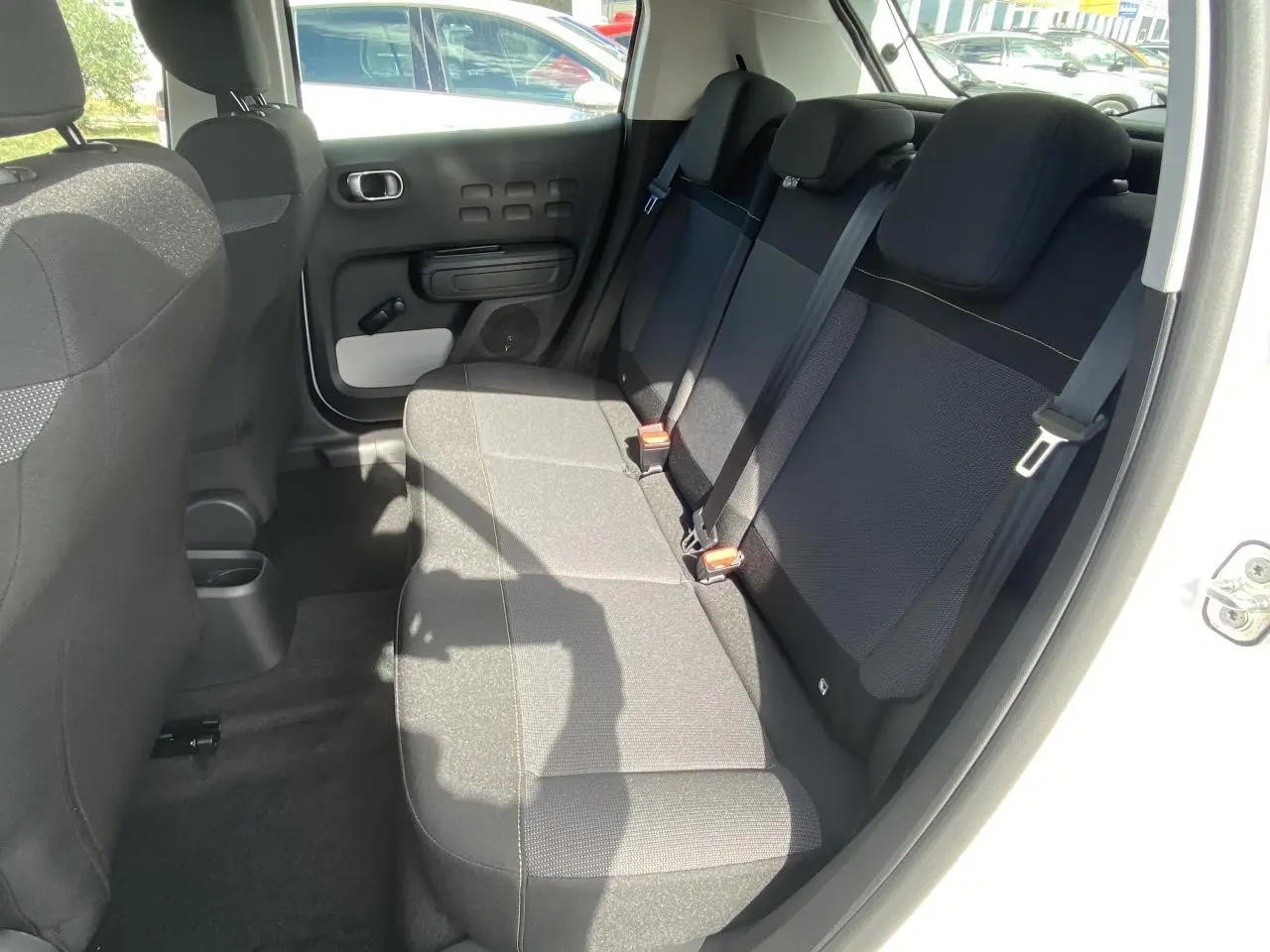 Vue intérieure côté droit sur la banquette arrière noire et grise d'une Citroën C3 1.5 BlueHDi 2022 blanche.