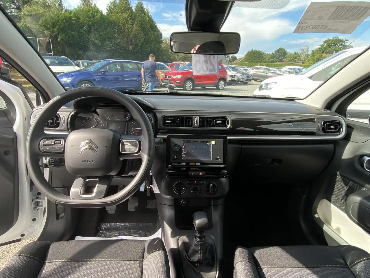 Intérieur de la Citroën C3 2022 blanc Banquise, vue du poste de conduite avec tableau de bord et volant multifonction.