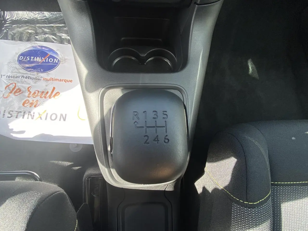 Le levier de vitesses manuel noir vu de dessus dans l'habitacle d'une Citroën C3 blanche de 2022.