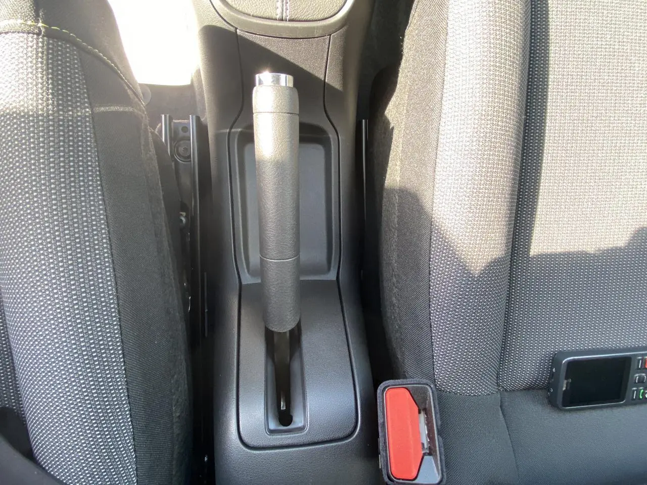 Vue rapprochée de la console centrale avec frein à main et sièges tissu gris de la Citroën C3 blanche 2022.