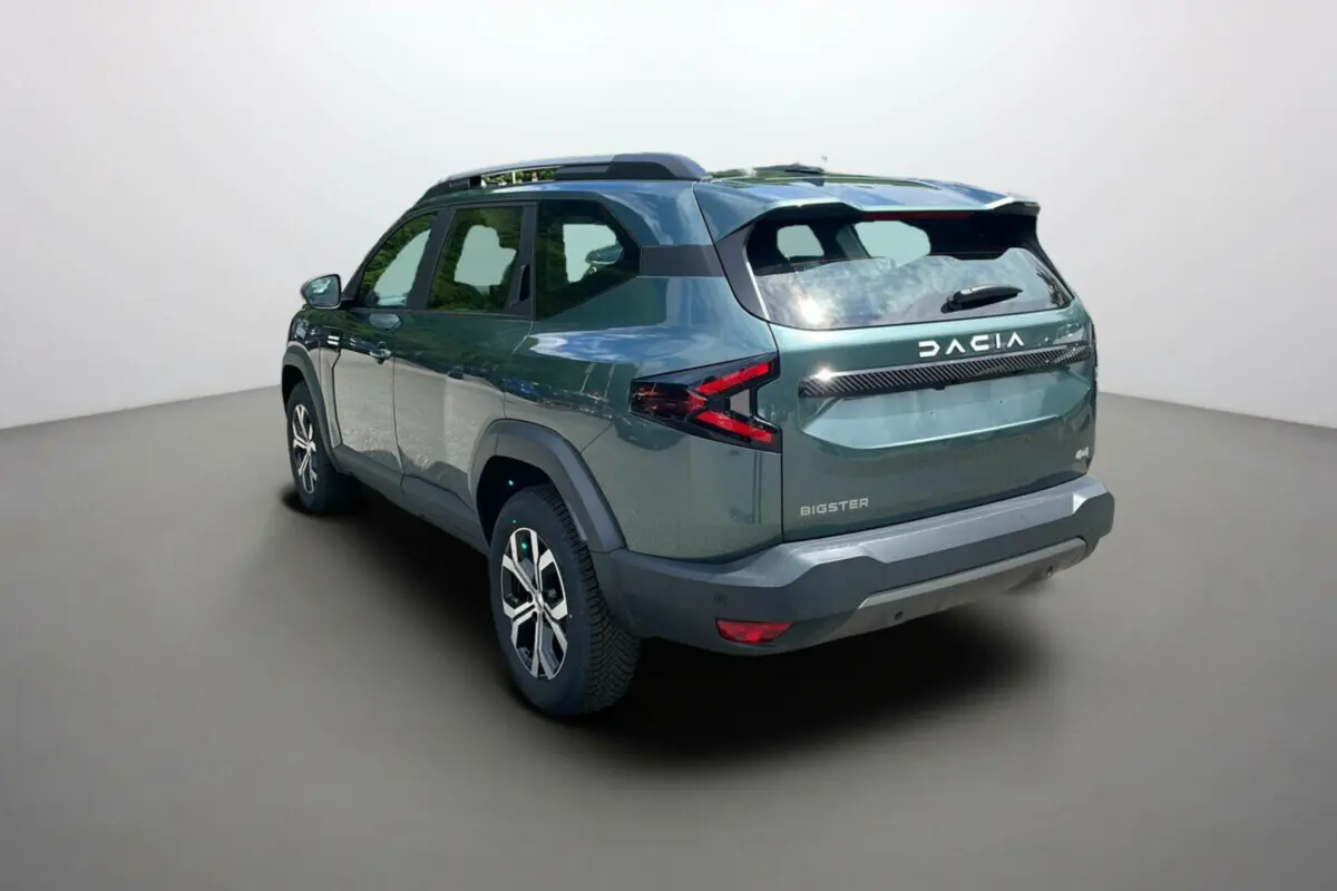 Vue 3/4 arrière droite du Dacia Bigster 2025 vert cèdre, avec logo DACIA et feux arrière en forme de flèche.