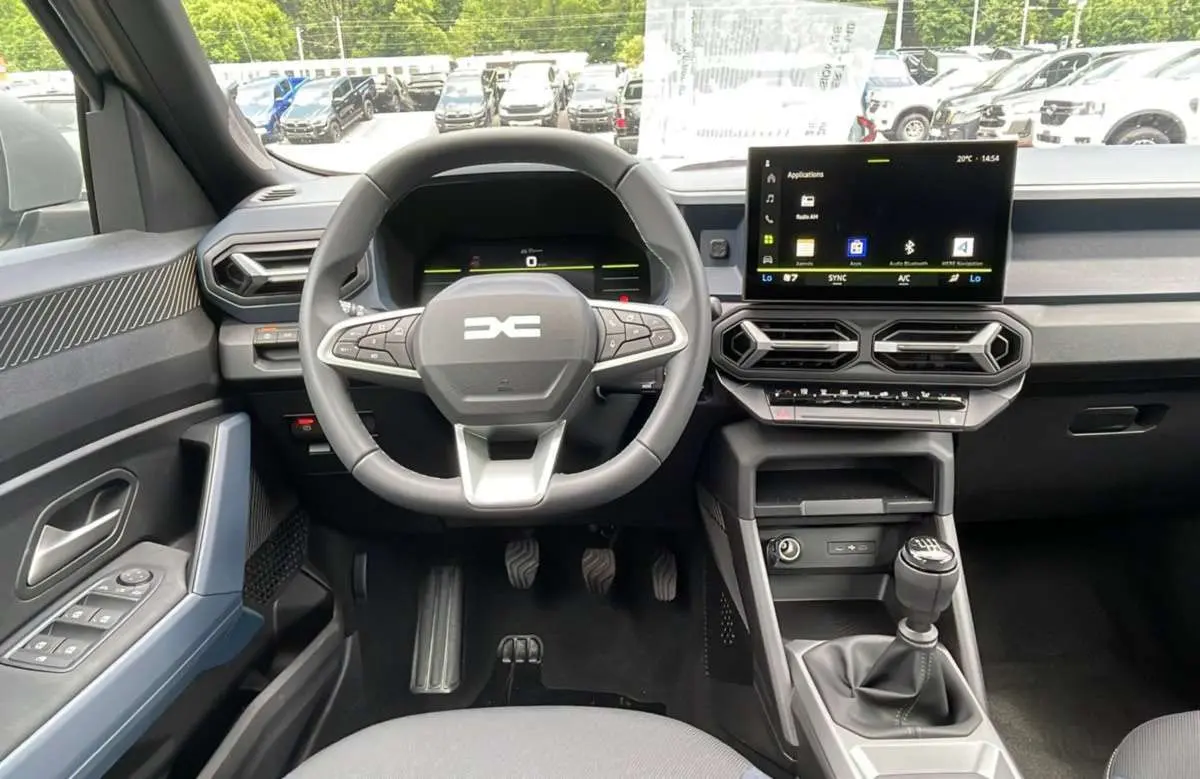 Vue intérieure centrée sur le volant et la console centrale du Dacia Bigster TCE 130 4x4 Expression Plus 2025.