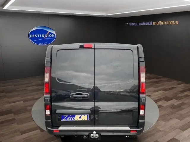 Vue arrière d'un Renault Trafic Cabine Approfondie noir 2025 avec attelage et lunette arrière ouvrante dans un showroom.