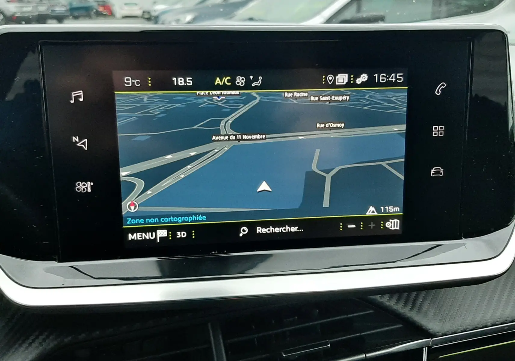 Écran tactile du système de navigation du Peugeot 2008 2023, avec vue extérieure floue d’un véhicule blanc nacré.