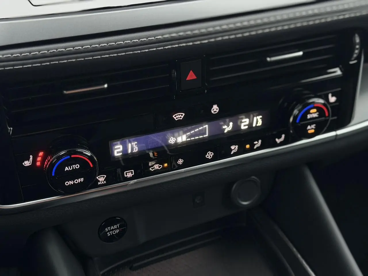 Gros plan sur la console centrale du Nissan Qashqai 2025, montrant les commandes de climatisation automatique bi-zone.
