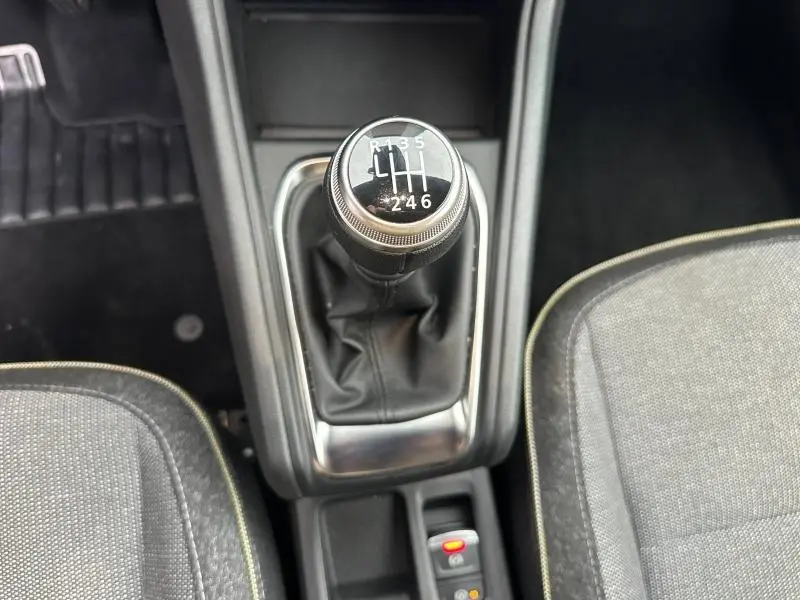 Gros plan sur le levier de vitesses manuel du Renault Captur 1.0 Eco-G 100ch Techno, intérieur tissu gris avec surpiqûres jaunes.