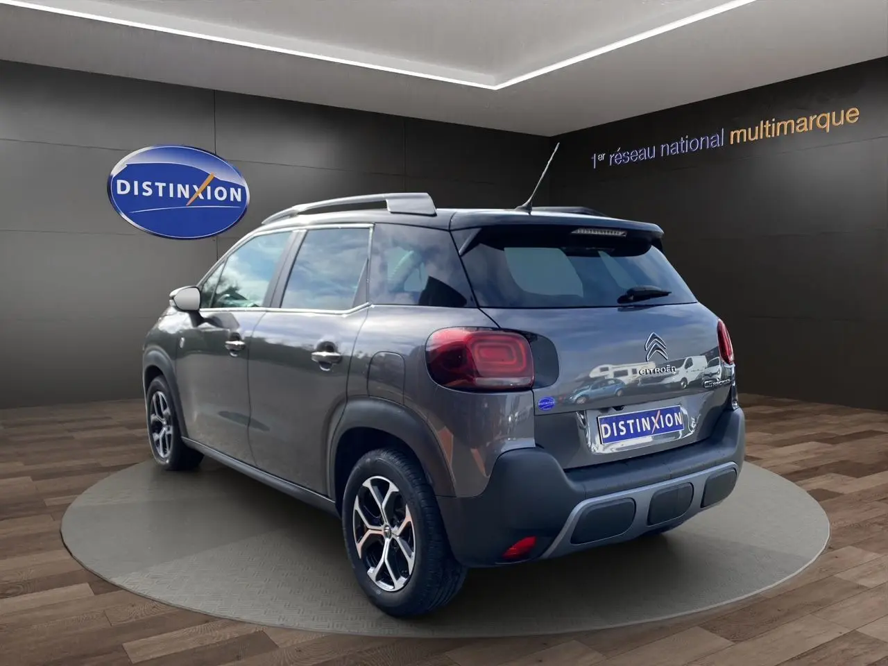 Vue 3/4 arrière droite d'un Citroën C3 Aircross gris platinium avec jantes alliage et caméra de recul visible.