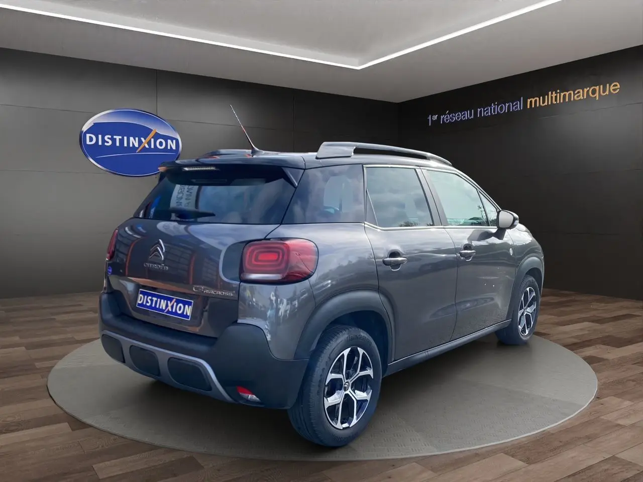 Vue 3/4 arrière droite d'un Citroën C3 Aircross gris platinium avec jantes alliage et caméra de recul visible.