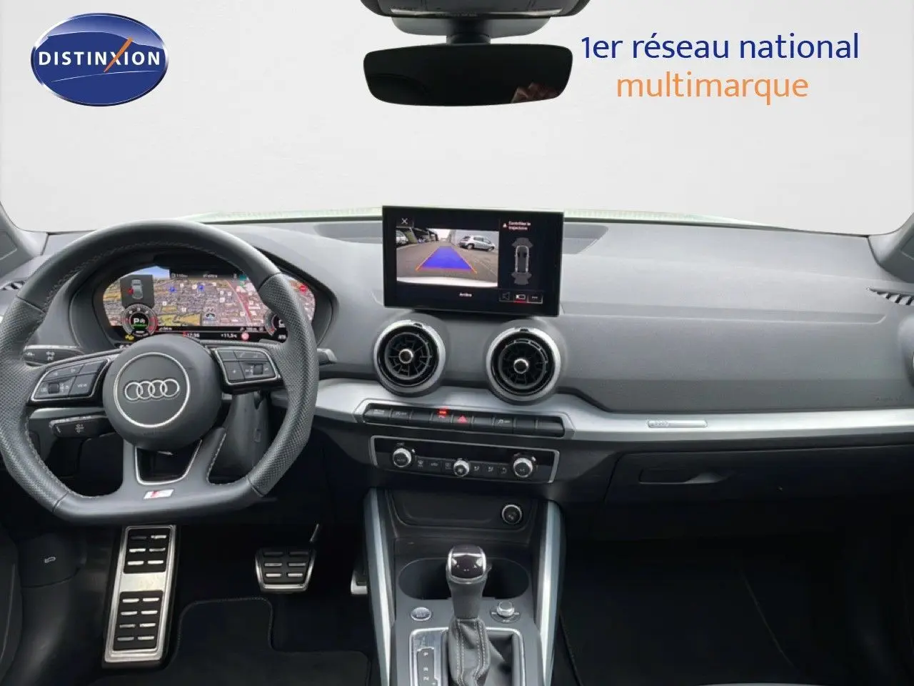 Vue intérieure avant de l'Audi Q2 35 2.0 TDI S-Line 2025 avec tableau de bord numérique et écran central affichant la caméra de recul.