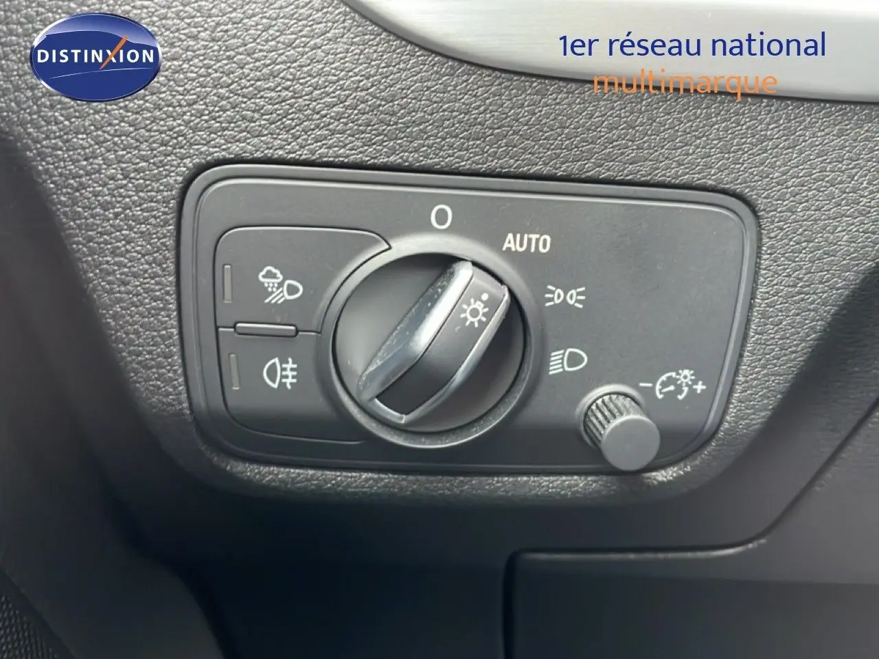 Commande des phares en gros plan à l'intérieur d'un Audi Q2 35 2.0 TDI S-Line, finition argent rose métal.