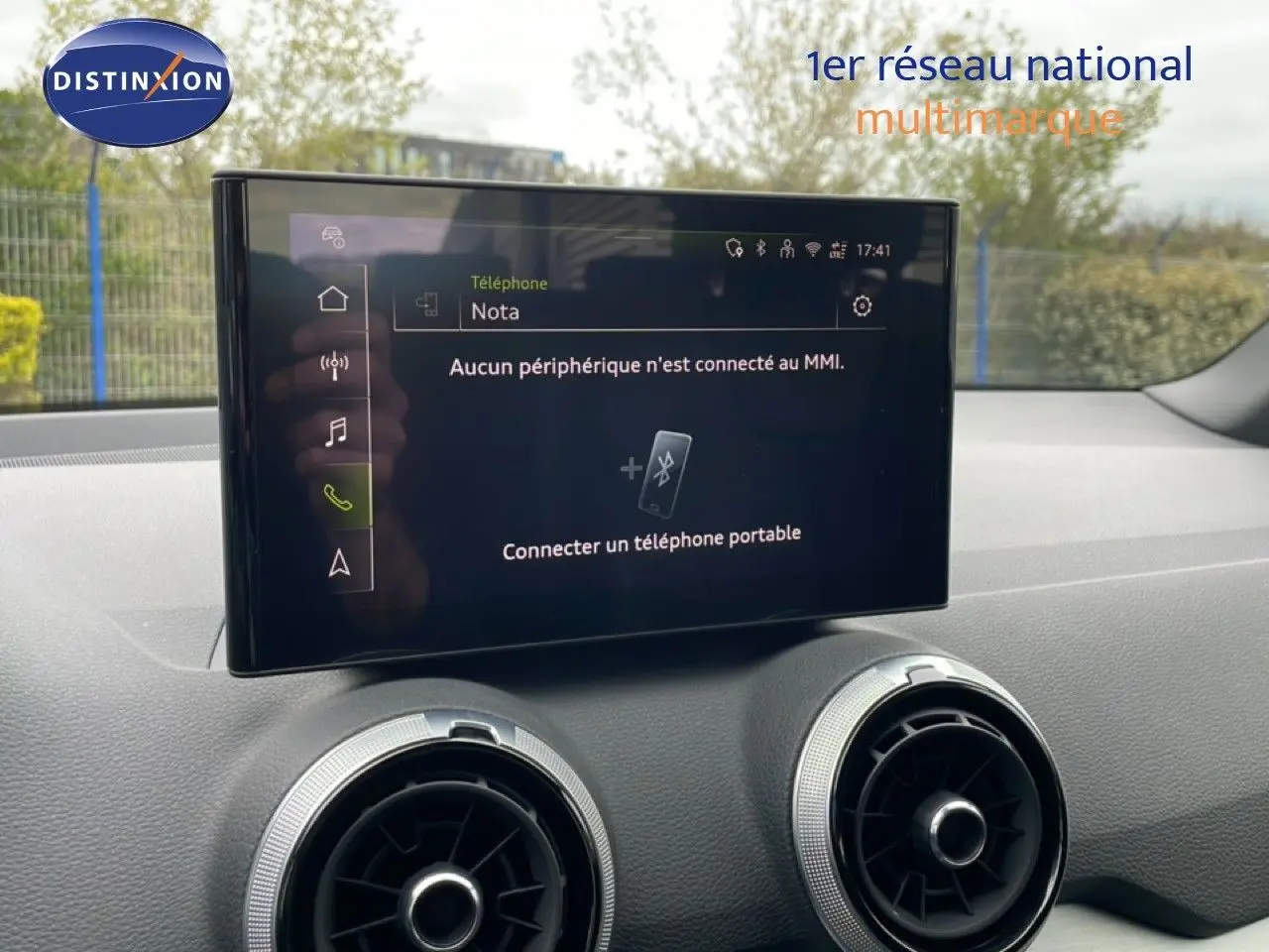 Écran tactile central affichant la connexion Bluetooth, avec deux aérateurs ronds sur tableau de bord noir.