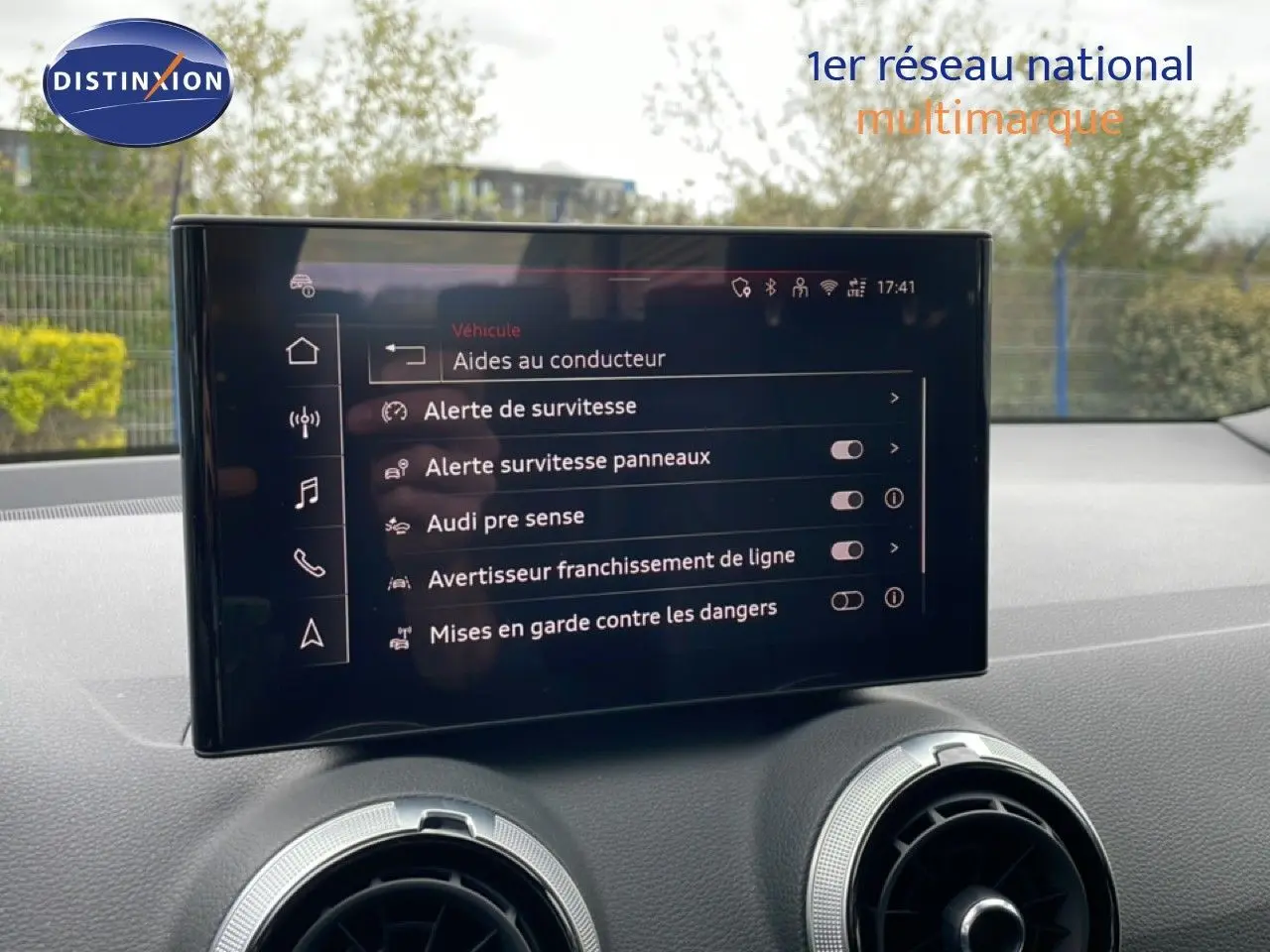 Écran central affichant les aides à la conduite dans l'Audi Q2 S-Line 2025, intérieur noir visible.
