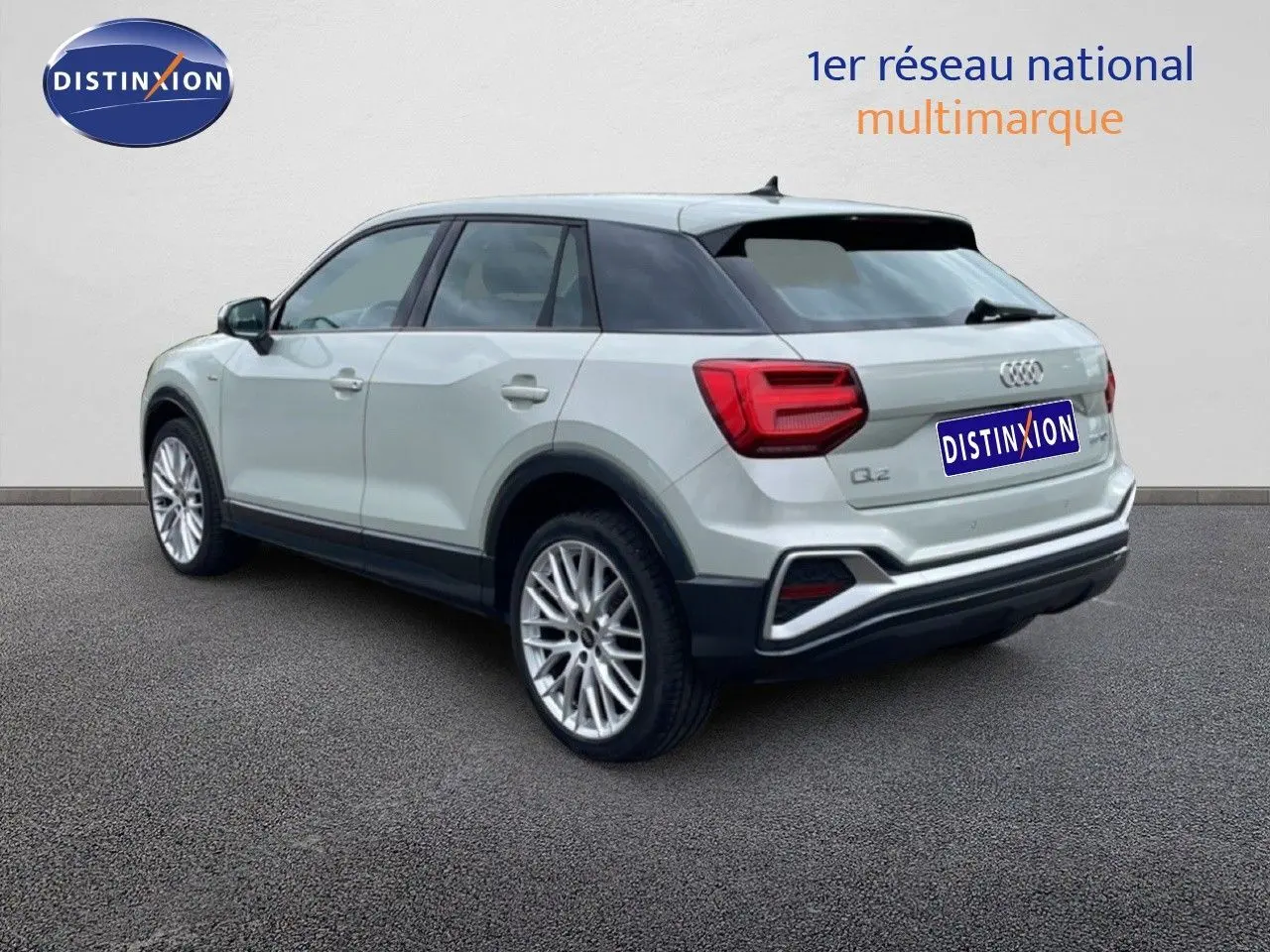 Audi Q2 argent rose métal vue 3/4 arrière droit, mettant en valeur ses feux arrière et jantes alliage.