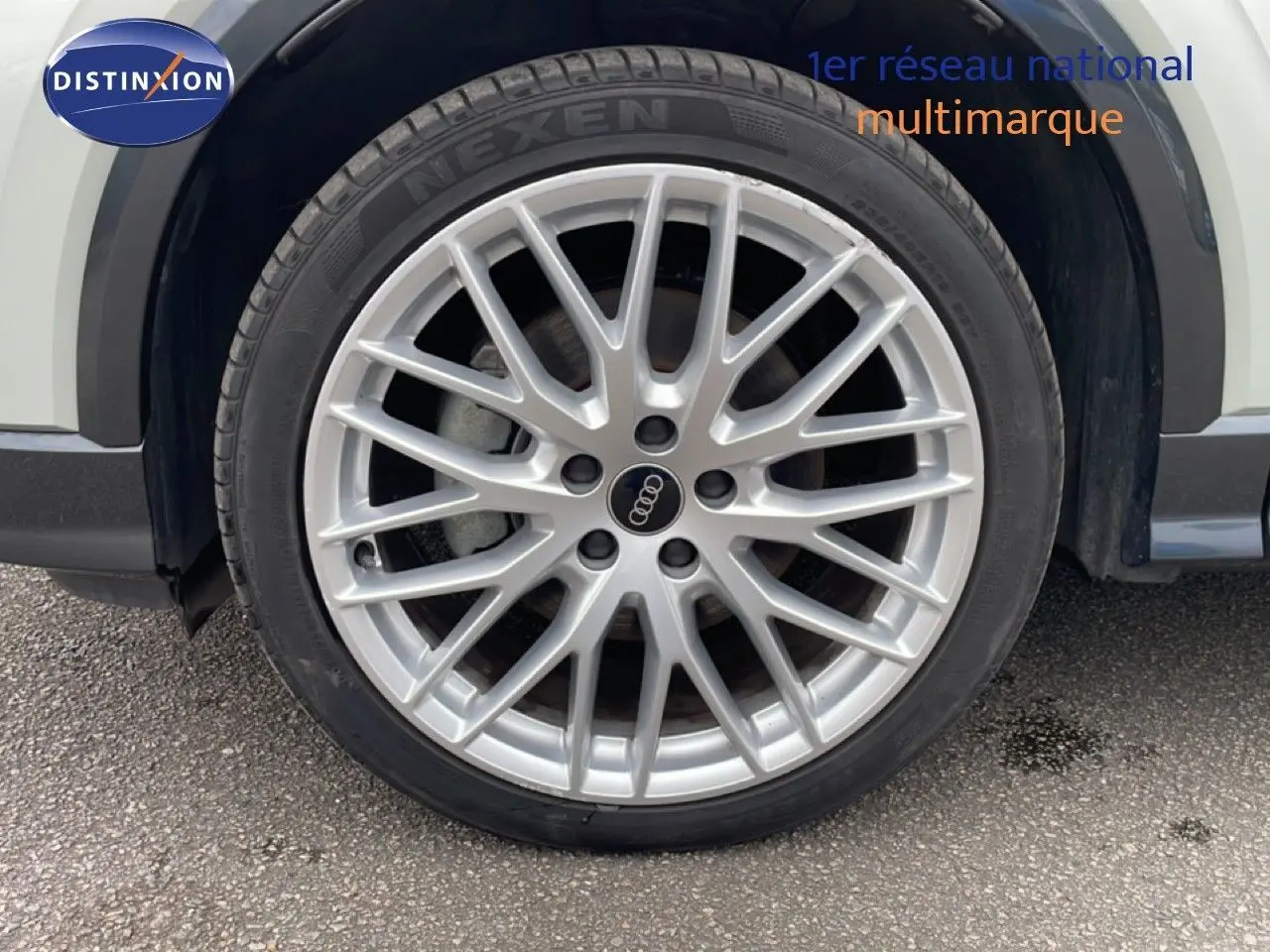 Gros plan sur la roue avant droite d’un Audi Q2 argent rose métal avec jante alliage multibranches.