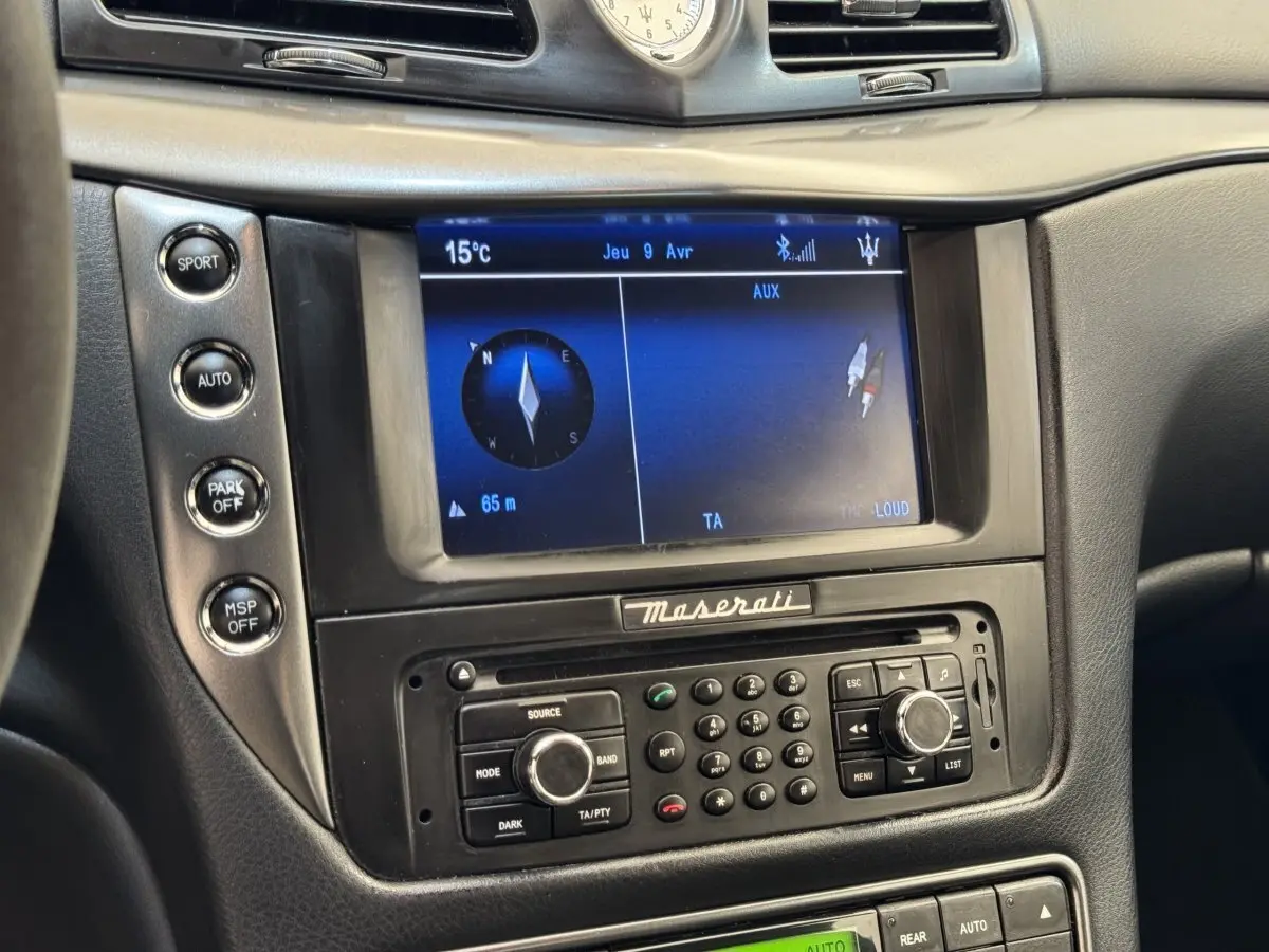 Gros plan sur la console centrale de la Maserati Granturismo S 4.7 2010, écran navigation et commandes noires.