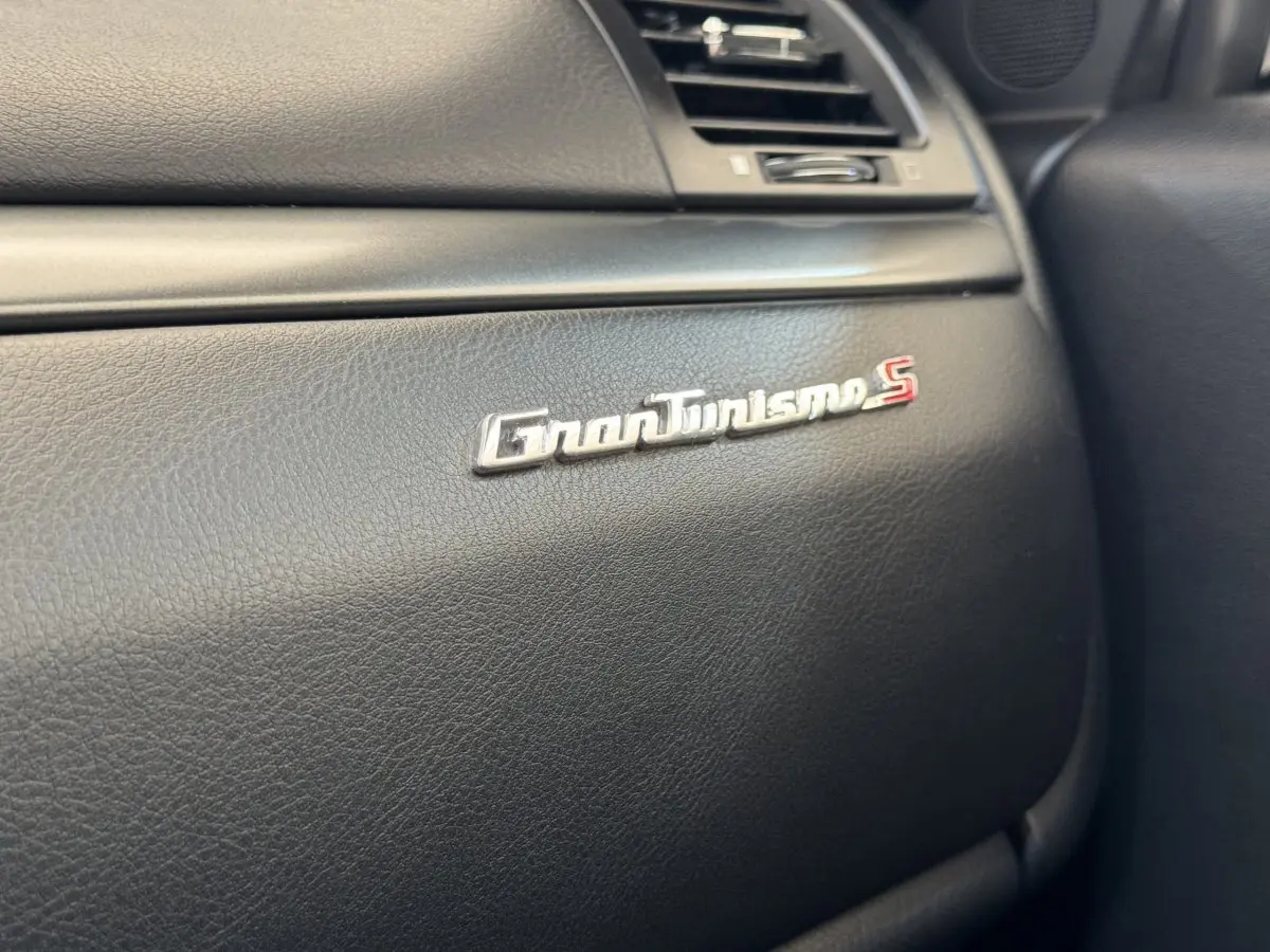 Gros plan sur l’inscription GranTurismo S en chrome sur la planche de bord noire du Maserati Granturismo S 2010.