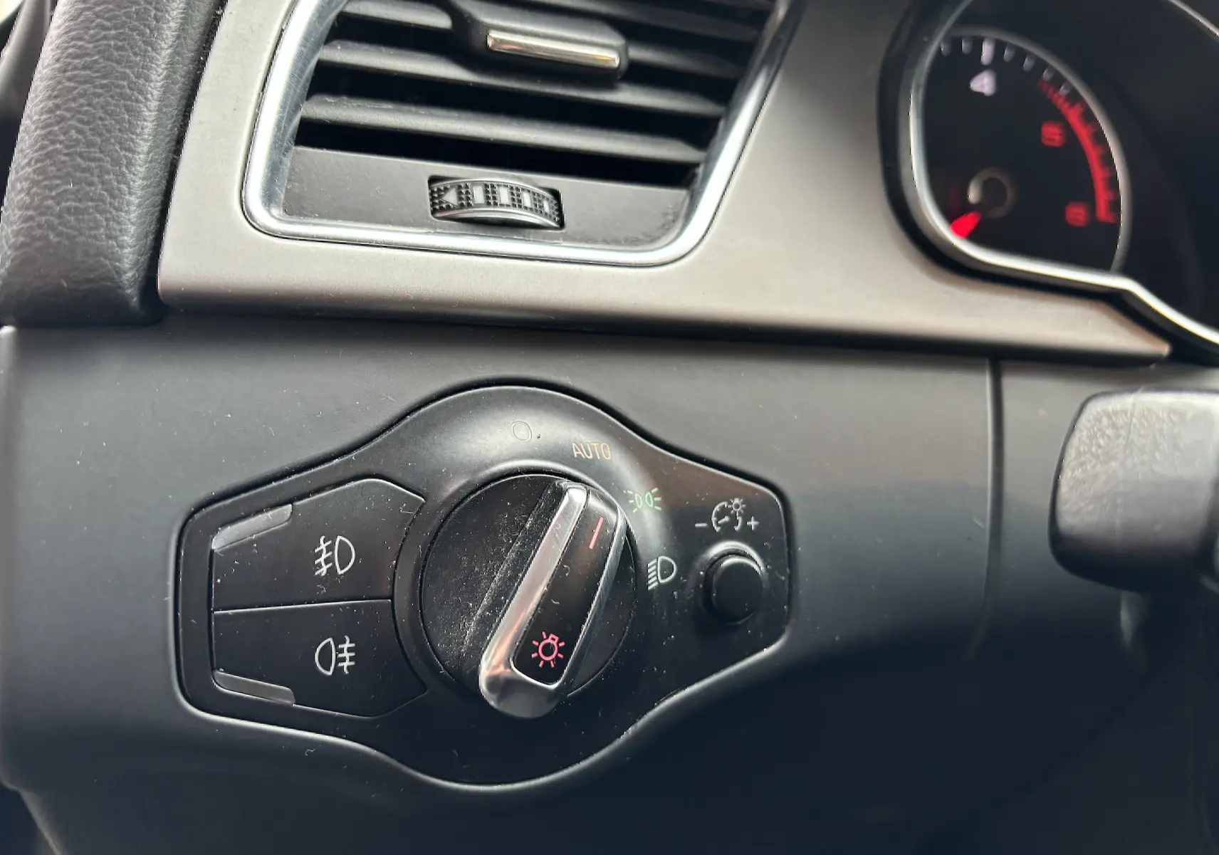 Gros plan sur le bouton de commande des phares dans l'habitacle noir de l'Audi A5 Sportback 2013.