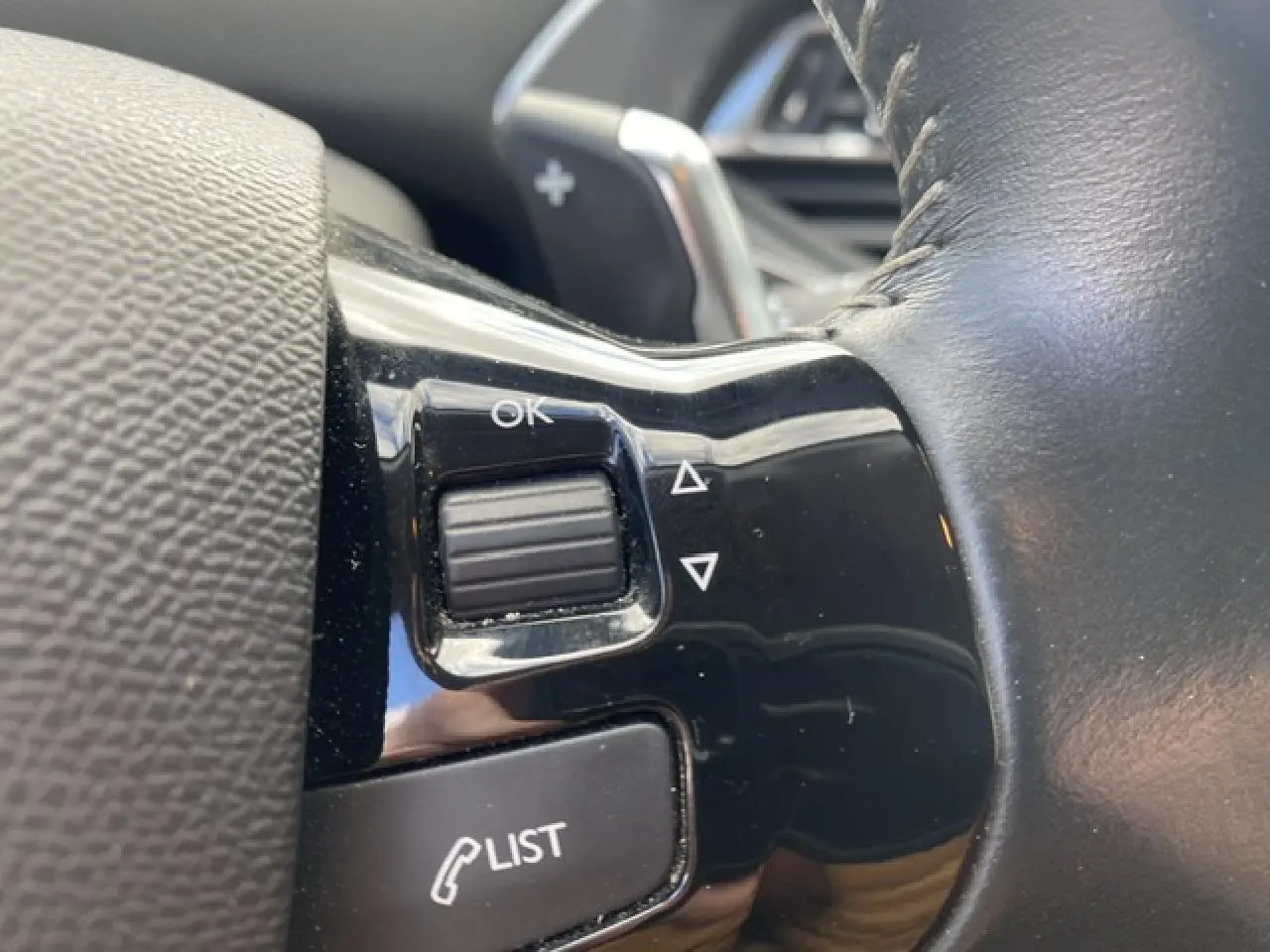 Gros plan sur les commandes au volant noir brillant du Peugeot 308 SW 2018, avec molette et bouton LIST visibles.