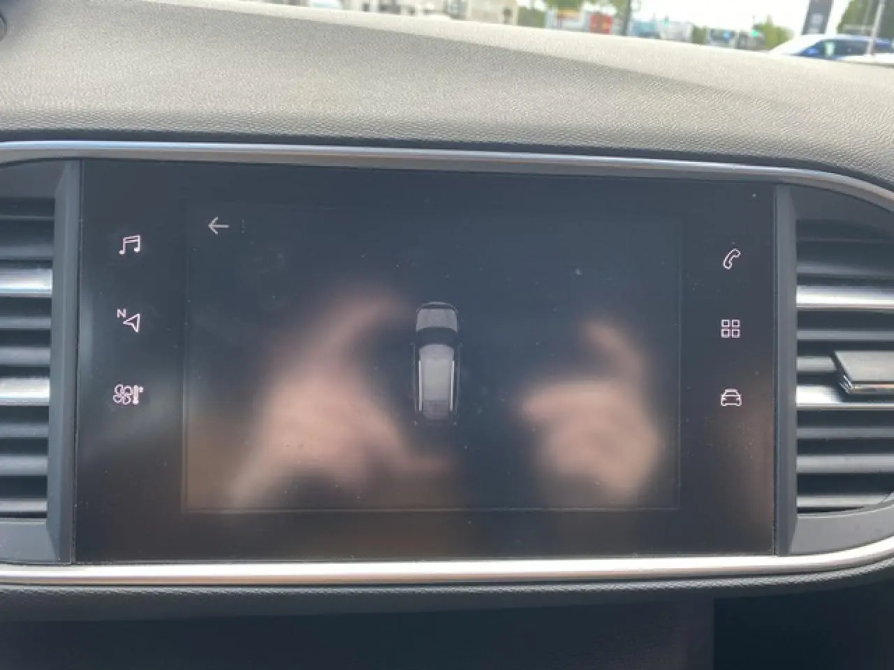 Écran tactile central de la Peugeot 308 SW 2018 affichant l'aide au stationnement dans un intérieur sombre.