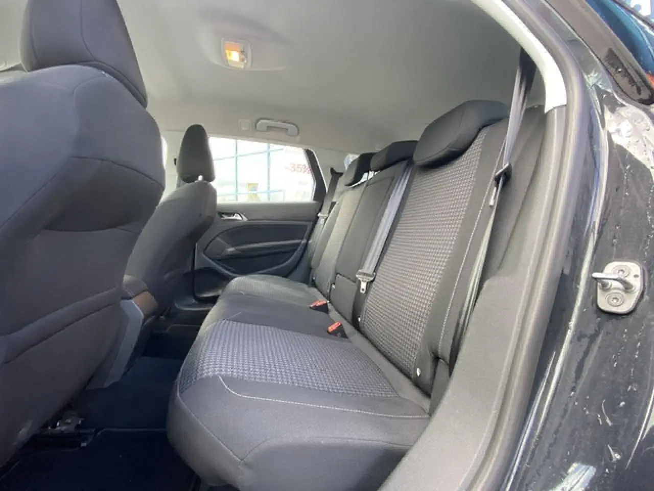 Vue intérieure côté droit sur la banquette arrière noire de la Peugeot 308 SW gris Hurricane avec porte ouverte.