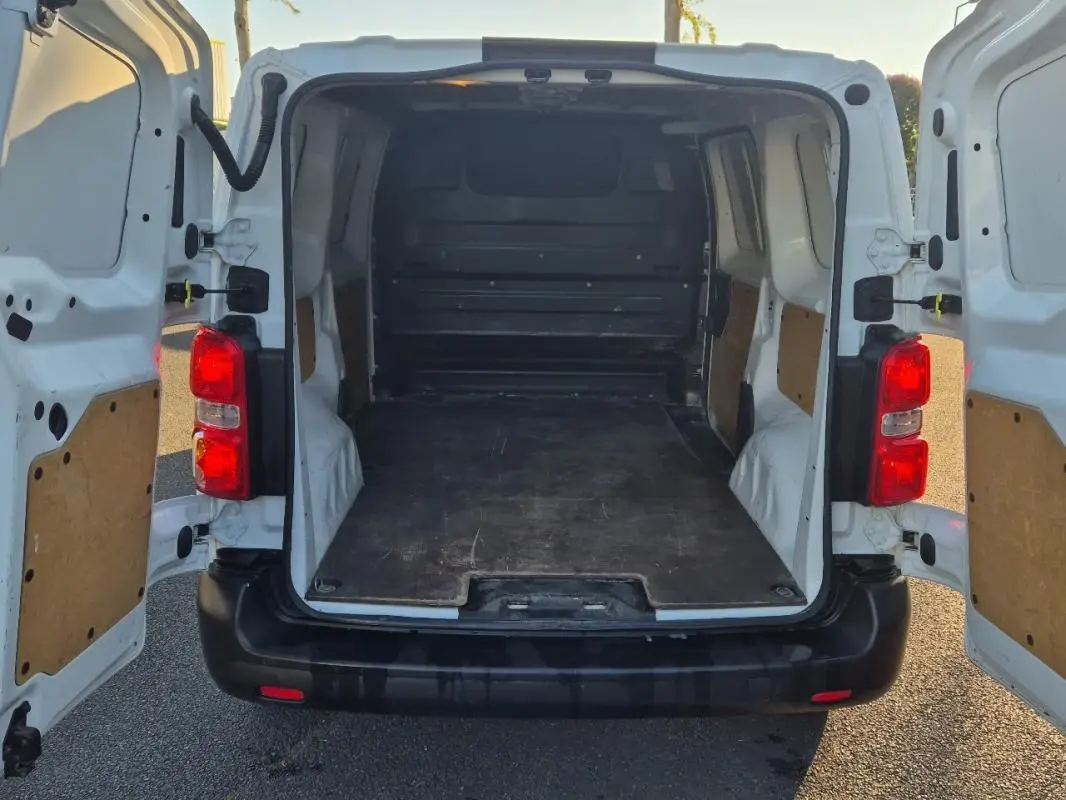 Vue arrière du Citroën Jumpy blanc 2019 avec portes ouvertes montrant l'espace de chargement vide et les feux rouges.