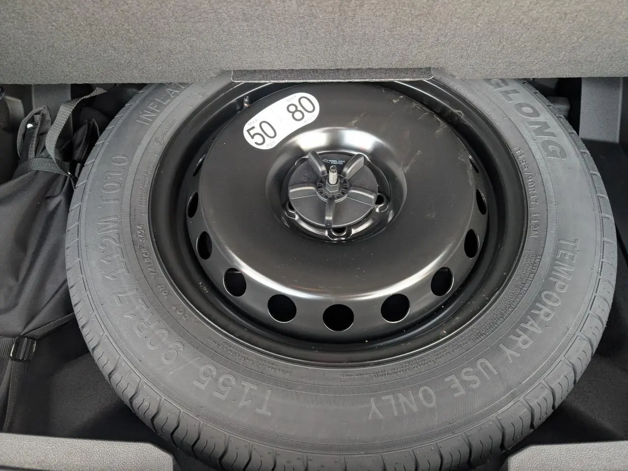 Gros plan sur la roue de secours temporaire noire dans le coffre du Renault Austral gris métallisé 2025.