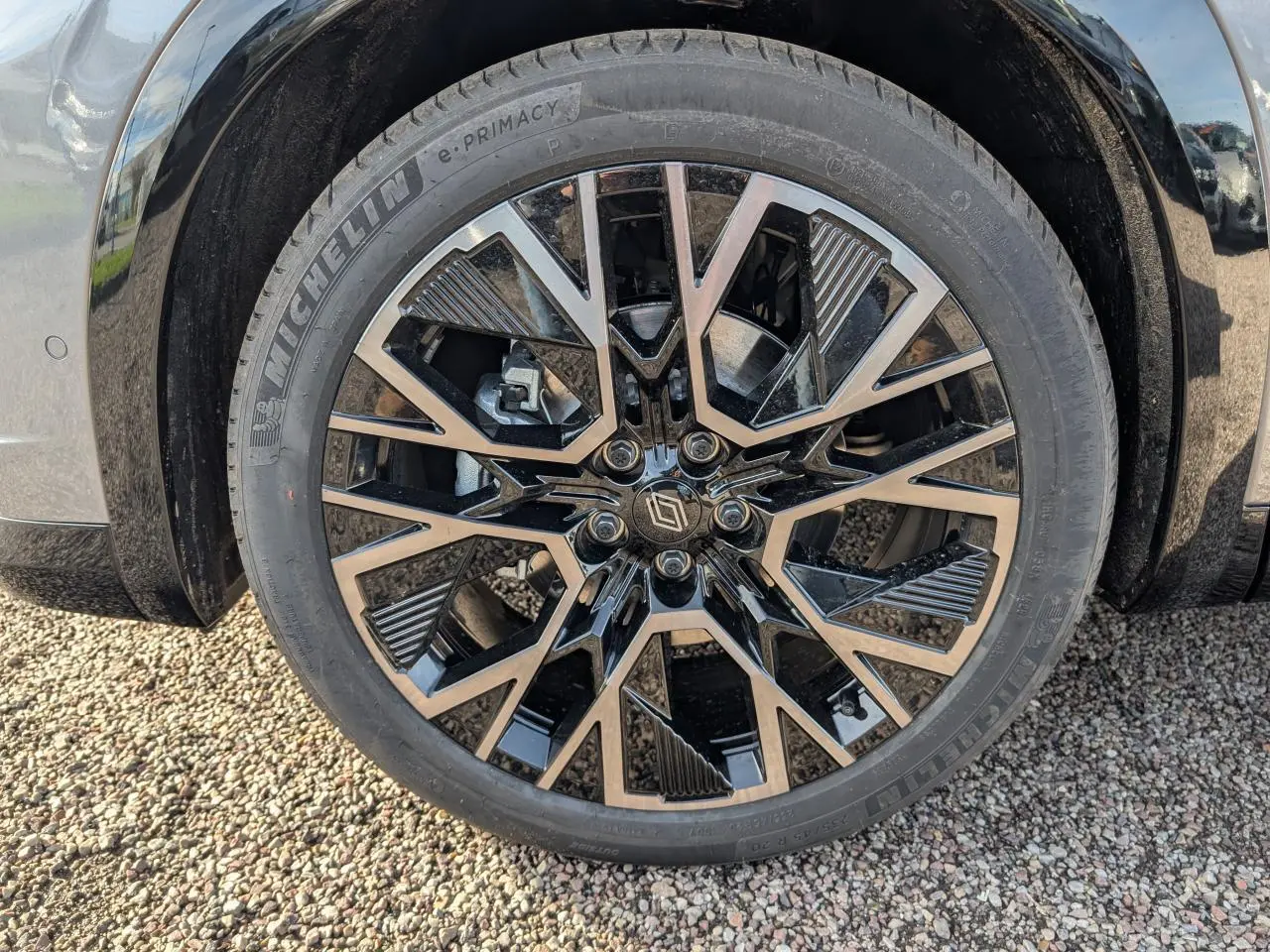 Gros plan sur la roue avant gauche du Renault Austral gris métallisé, jante alliage 20 pouces noire et diamantée.