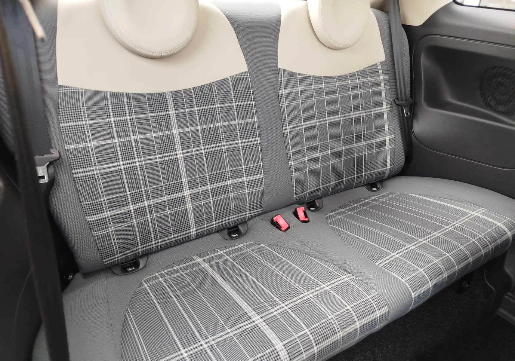 Vue intérieure sur la banquette arrière à motifs carreaux gris et beige de la FIAT 500 Lounge 2017.