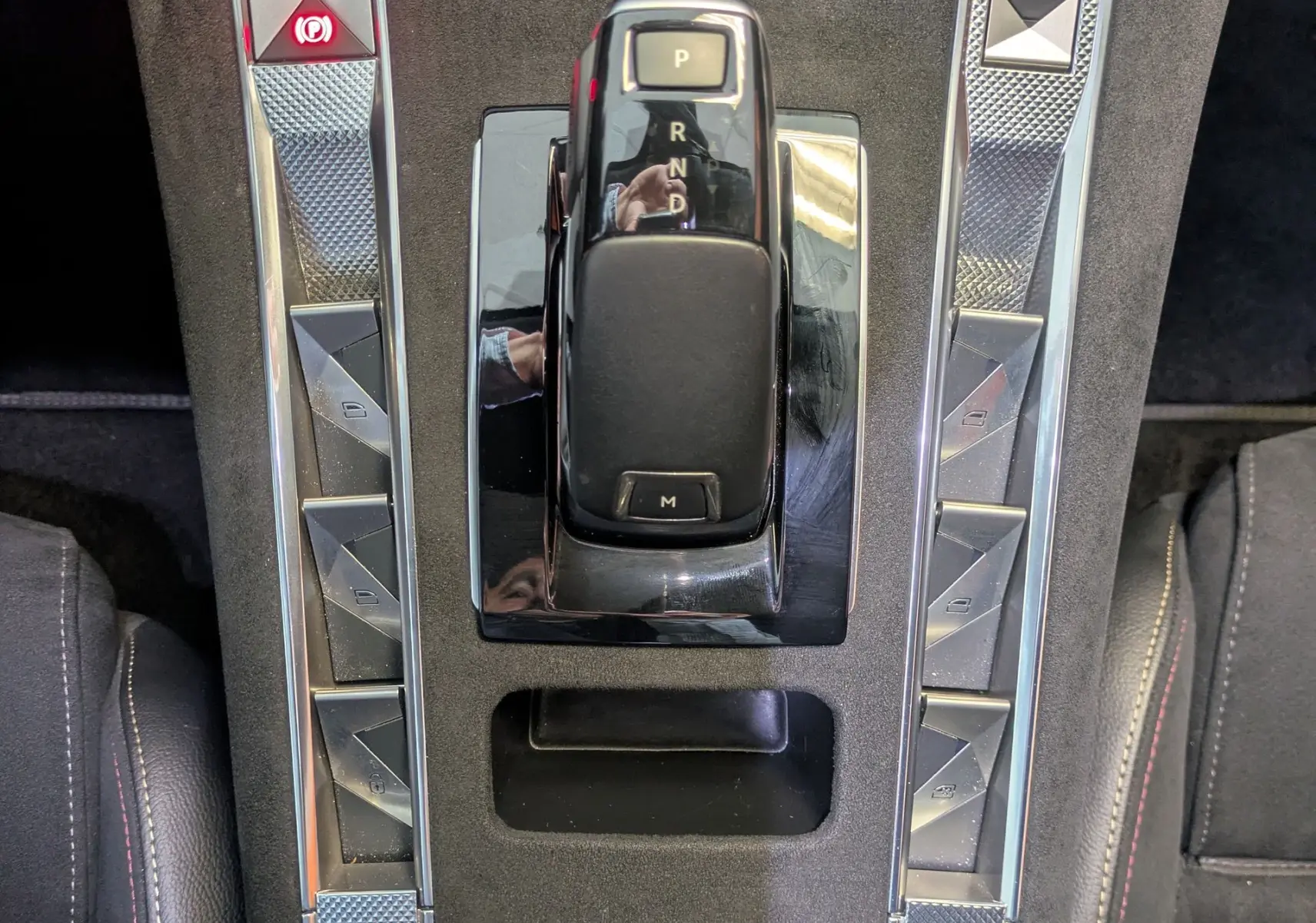 Vue plongeante sur la console centrale du DS7 gris laque, mettant en valeur le levier de vitesses automatique et les commandes argentées.