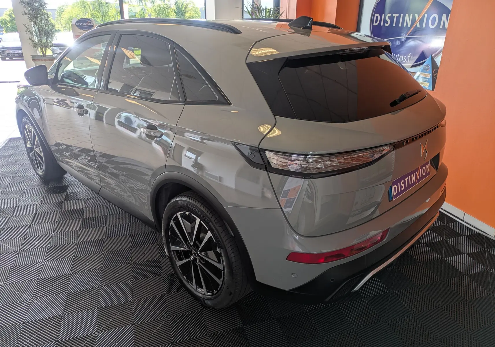 Vue 3/4 arrière droite du SUV DS7 gris laqué avec jantes alliage 19 pouces et vitres arrière teintées.