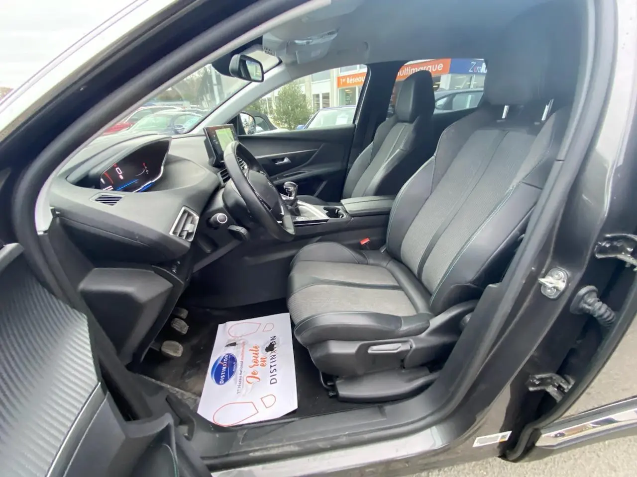 Vue intérieure côté conducteur du Peugeot 3008 gris platinium, montrant sièges avant et tableau de bord moderne avec écran tactile.