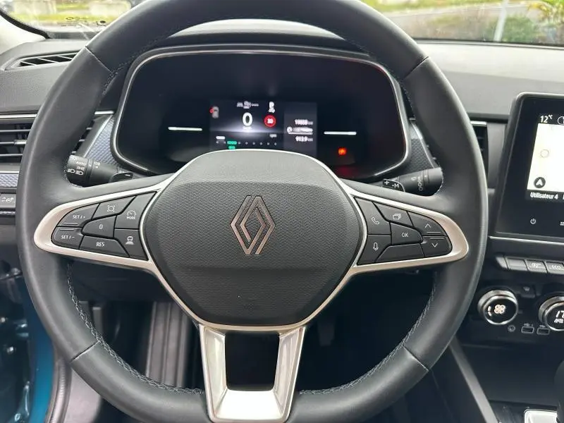 Vue centrée sur le volant du Renault Arkana 2025, avec tableau de bord numérique et commandes intégrées.