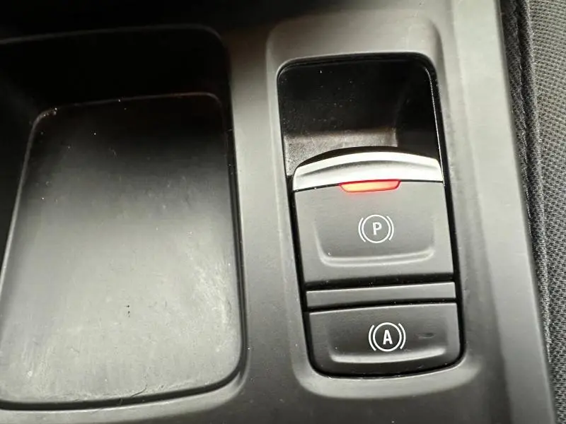 Gros plan sur les commandes de frein à main électronique et arrêt automatique du Renault Arkana 2025, intérieur noir.