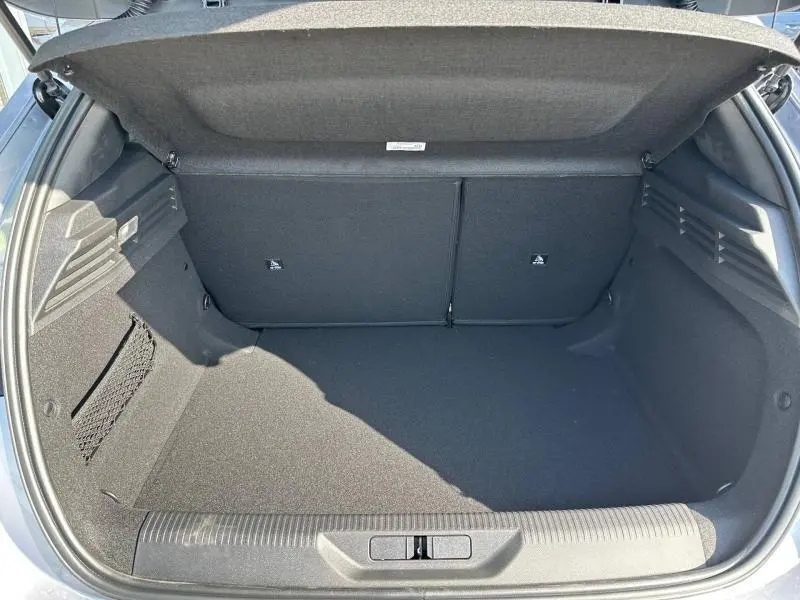 Coffre ouvert vu de l'arrière d'une Peugeot 308 gris Artense, montrant un espace de chargement propre et spacieux.