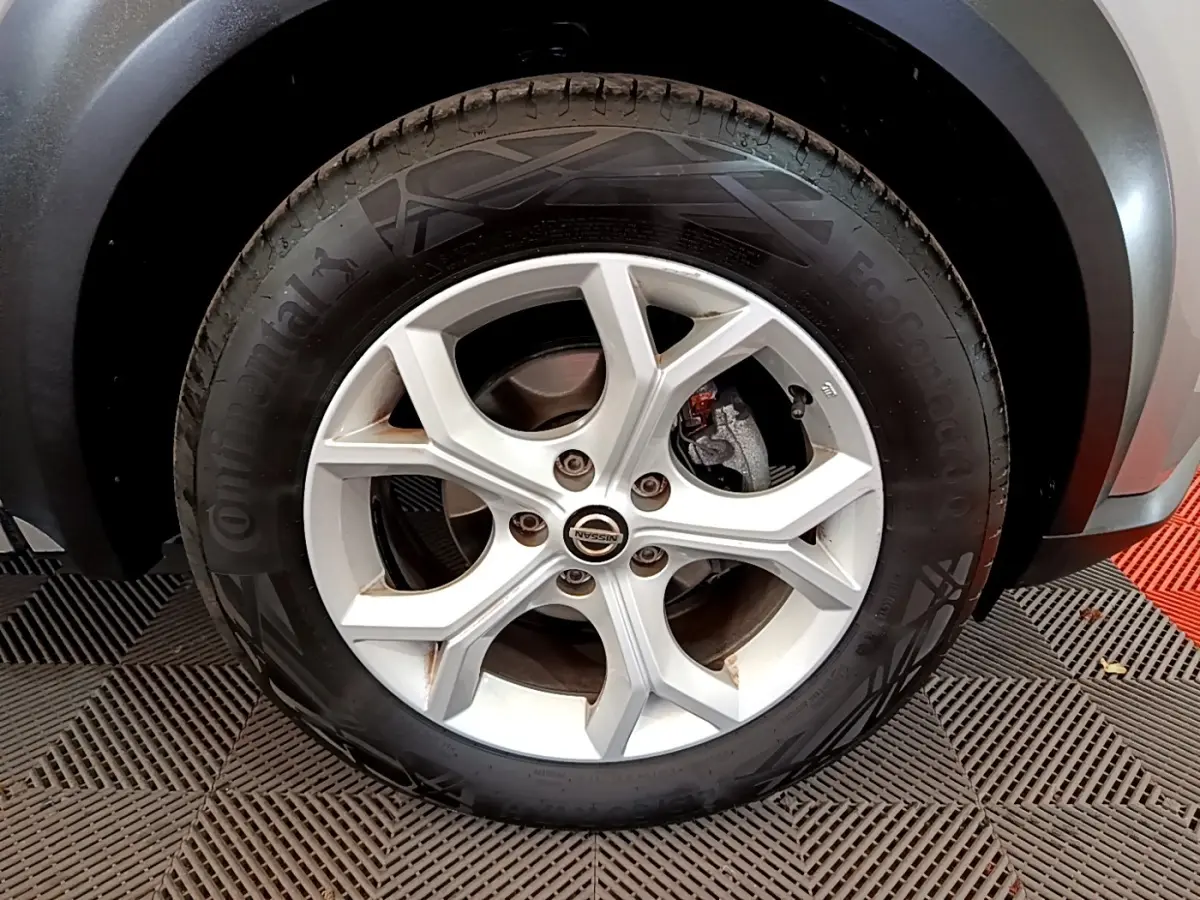 Gros plan sur la roue avant droite du Nissan Juke gris clair 2022 avec jante alliage et pneu Continental.