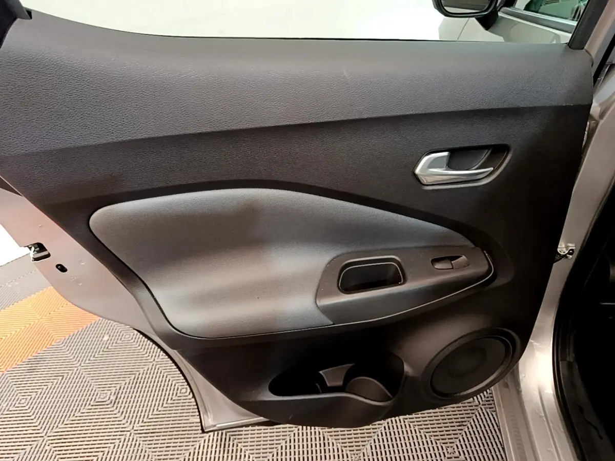 Vue intérieure de la porte avant droite gris clair du Nissan Juke 2022 avec poignée et haut-parleur intégrés.