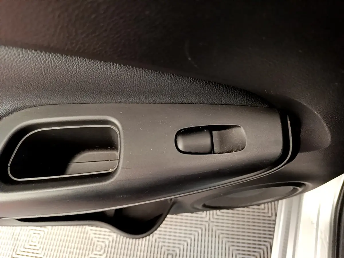 Gros plan sur la poignée intérieure de porte noire du Nissan Juke 2022, côté conducteur, avec bouton de verrouillage.