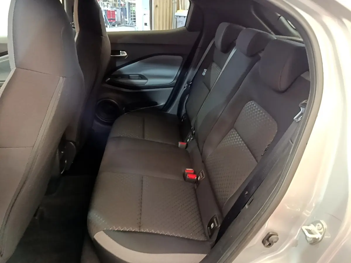 Vue intérieure côté droit sur la banquette arrière noire du Nissan Juke gris clair, avec porte ouverte.