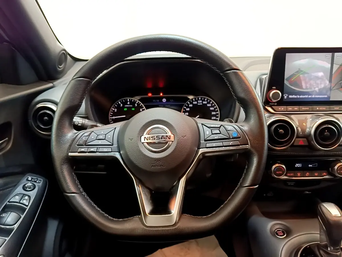 Vue intérieure centrée sur le volant cuir noir du Nissan Juke 2022 avec tableau de bord et écran tactile.