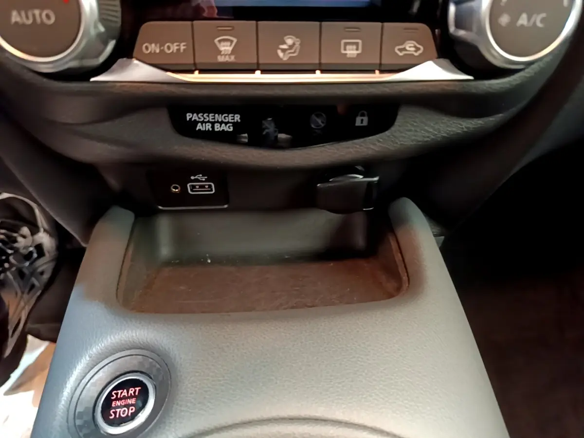 Détail de la console centrale du Nissan Juke gris clair 2022, avec bouton start/stop et ports USB visibles.