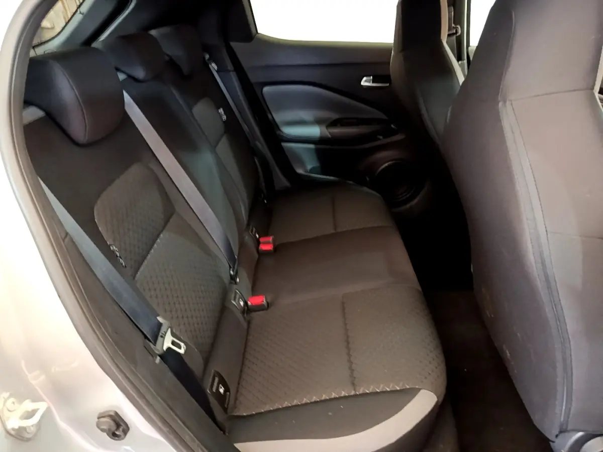 Vue intérieure côté gauche montrant la banquette arrière noire du Nissan Juke gris clair 2022.