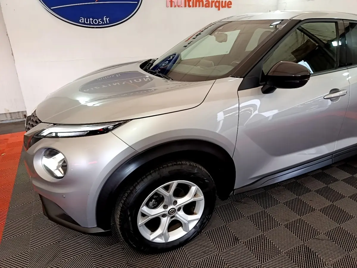 Vue 3/4 avant droit d'un Nissan Juke Business+ gris clair avec jantes alliage et rétroviseurs noirs.