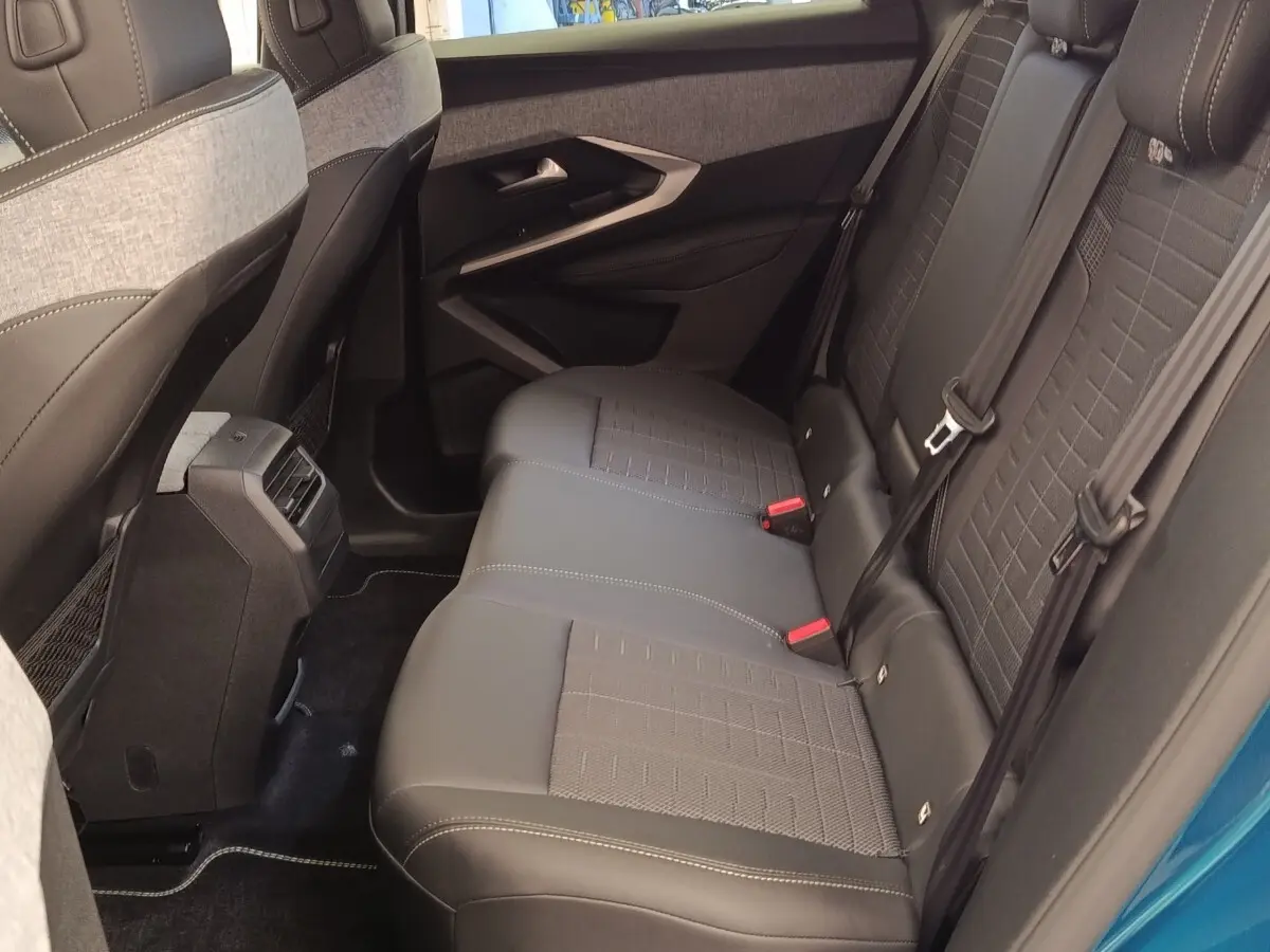 Vue intérieure côté gauche sur la banquette arrière grise du Peugeot 3008 bleu, avec ceinture de sécurité et porte ouverte.