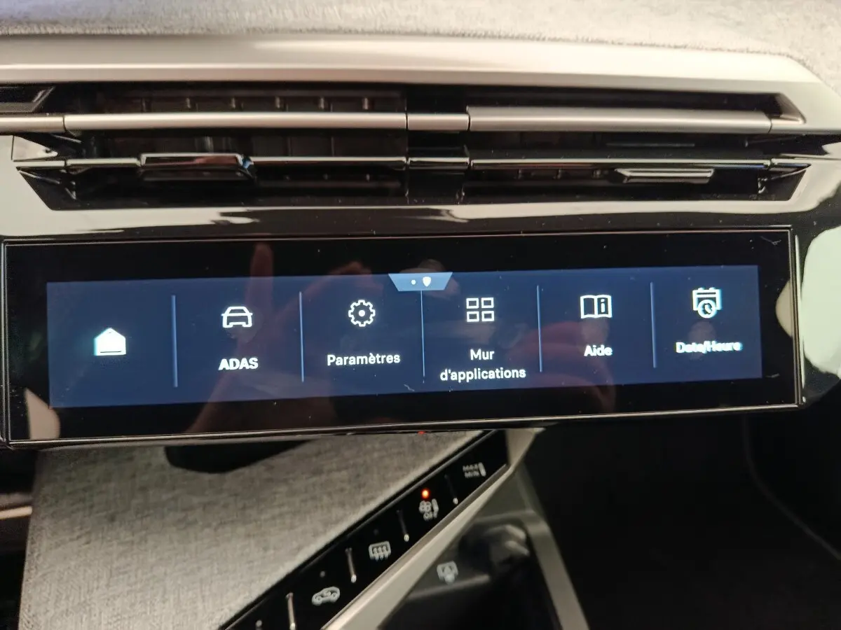 Écran tactile central du tableau de bord du Peugeot 3008 bleu, affichant le menu des paramètres et aides.